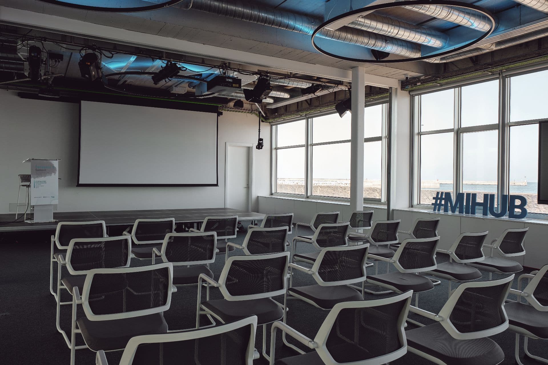 Escenario de auditorio con pantalla de proyección
